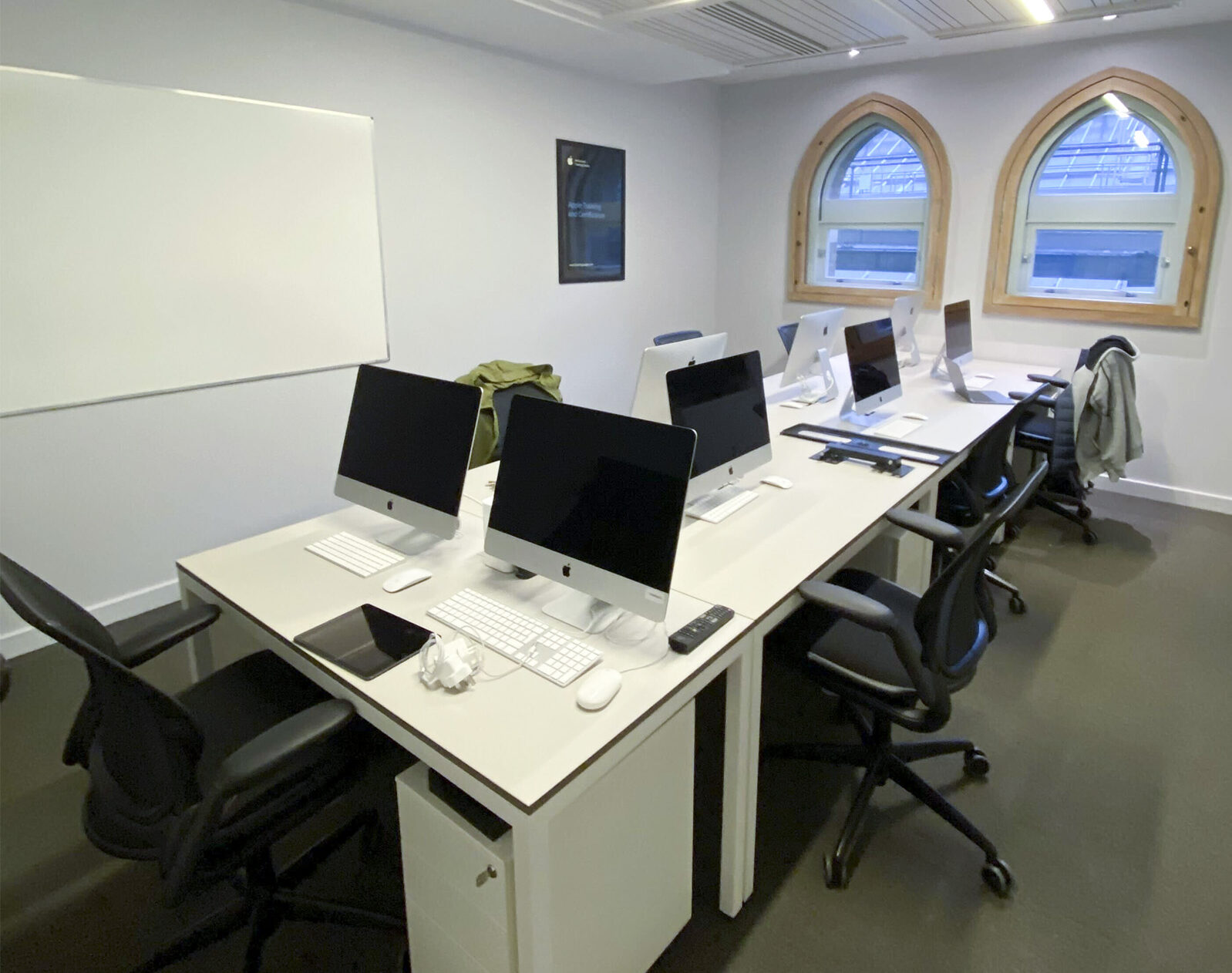 Inside the new training classroom with several macs set up and a whiteboard on the wall.