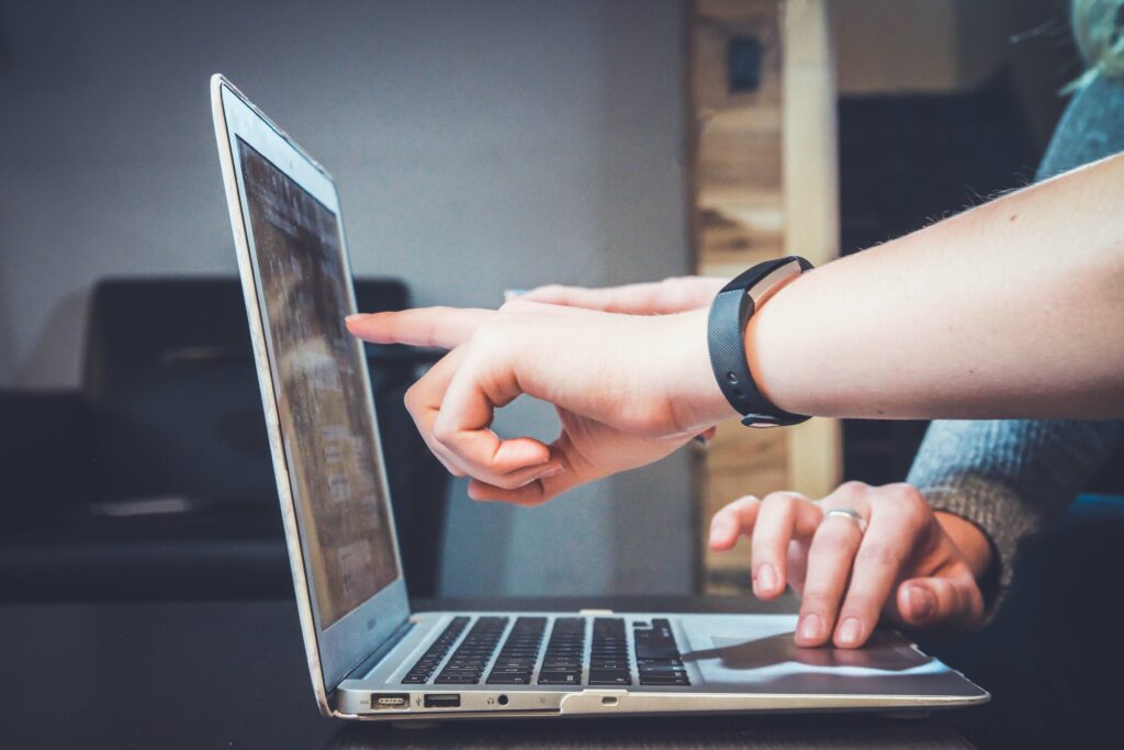 Students pointing to a Macbook device screen to represent mac management for beginners