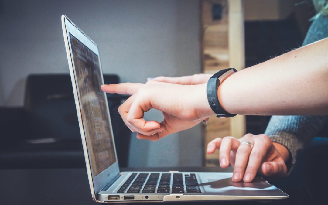 Students pointing to a Macbook device screen to represent mac management for beginners